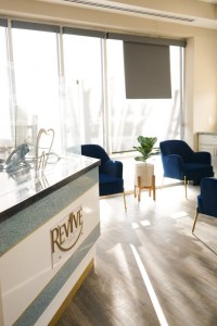 Bright dental office reception and waiting area with comfortable seating